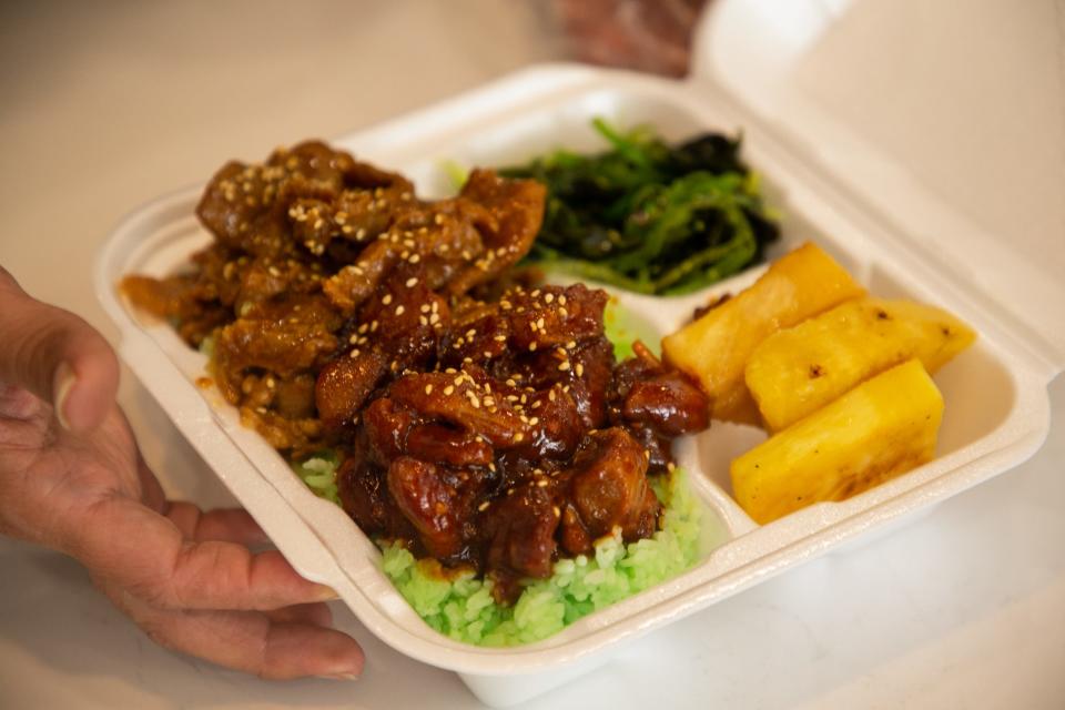 A plate of Aloha rice, grilled pineapple, seaweed salad and chicken is boxed up for a customer at Aloha! Pacific Island Grill on Saturday, May 27, 2023.