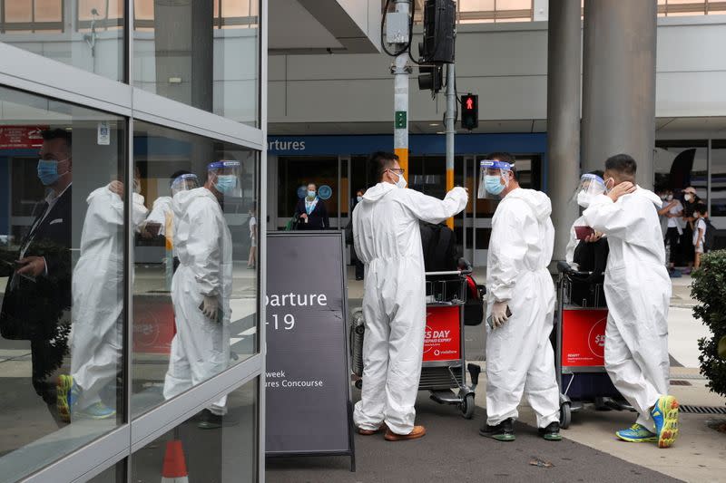 Travellers wear personal protective equipment outside the international terminal at Sydney Airport in Sydney