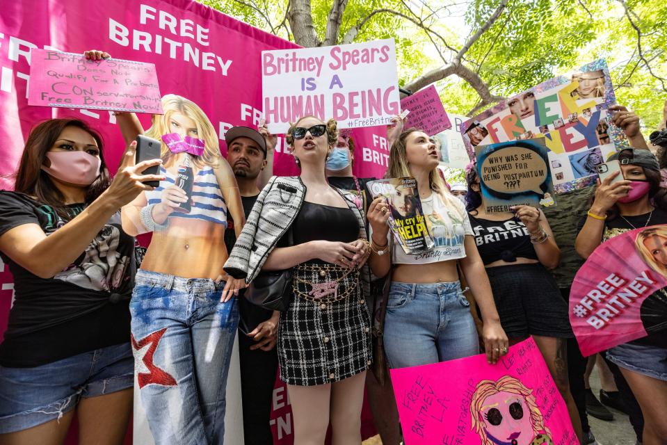 A row of young women hold signs in support of Britney Spears