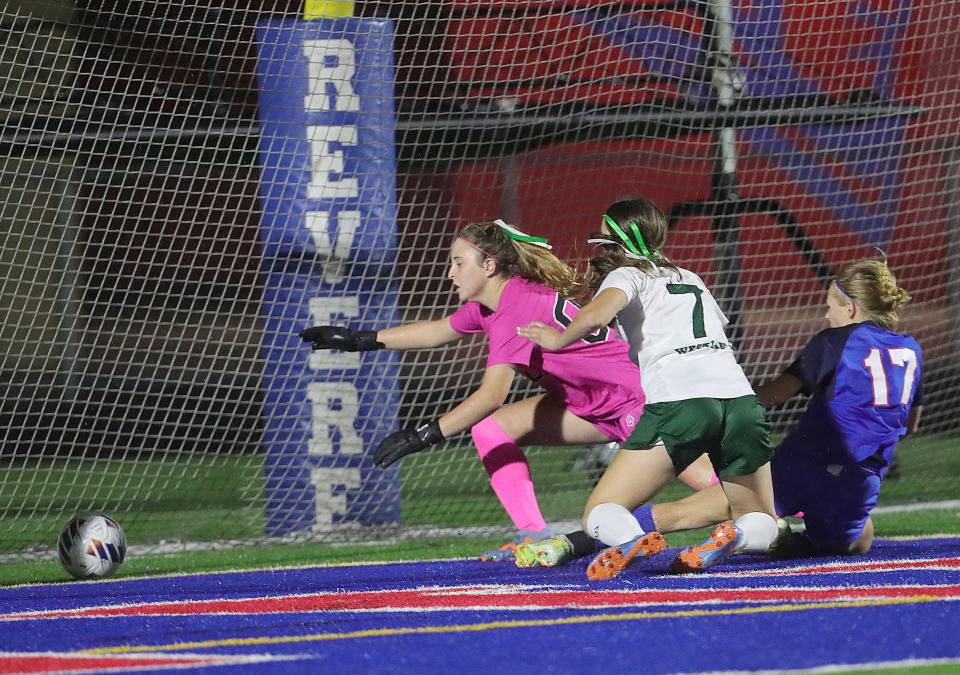 Revere's Zsofia Jakab (17) slips the game-winning shot past Westlake goalie Kylie Colacarro and Ellen Kruger in overtime to give the Minutemen a 3-2 win in a Division I sectional final Thursday in Bath Township.