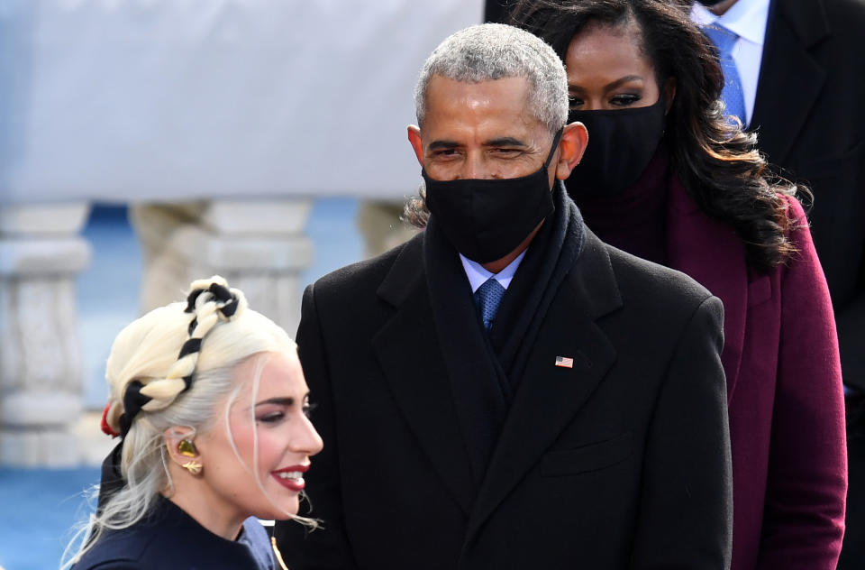 Former US First Lady Michelle Obama and Former US President Barack Obama as US singer Lady Gaga arrives during the inauguration of Joe Biden as the 46th US President, on the West Front of the US Capitol in Washington, DC on January 20, 2021. 