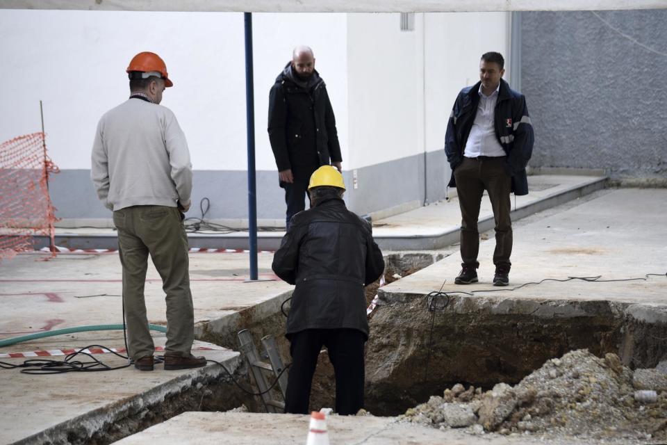 Experts check the location where an unexploded World War II bomb was found 5 meters (over 16 feet) deep, at a gas station in the northern Greek city of Thessaloniki, on Thursday, Feb. 9, 2016. Authorities in Greece's second-largest city on Sunday are planning to evacuate up to 60,000 residents from their homes so experts can safely dispose of the unexploded World War II bomb. (AP Photo/Giannis Papanikos)