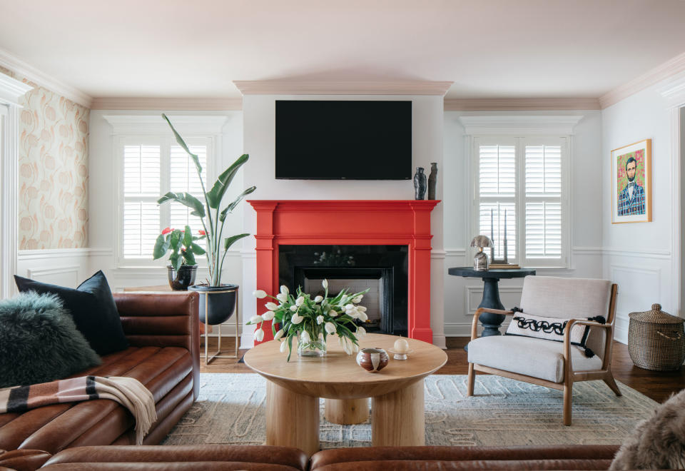 a living room with a red painted fireplace