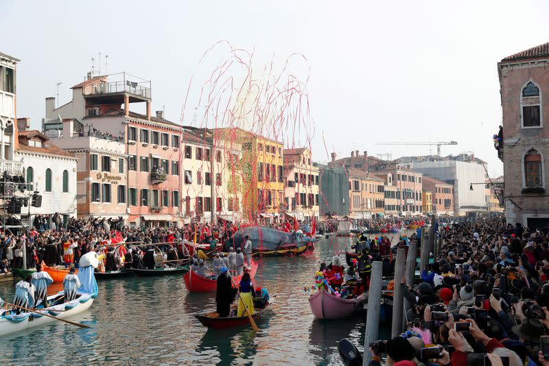 Venetians row during the masquerade parade on the Grand Canal during the Carnival in Venice