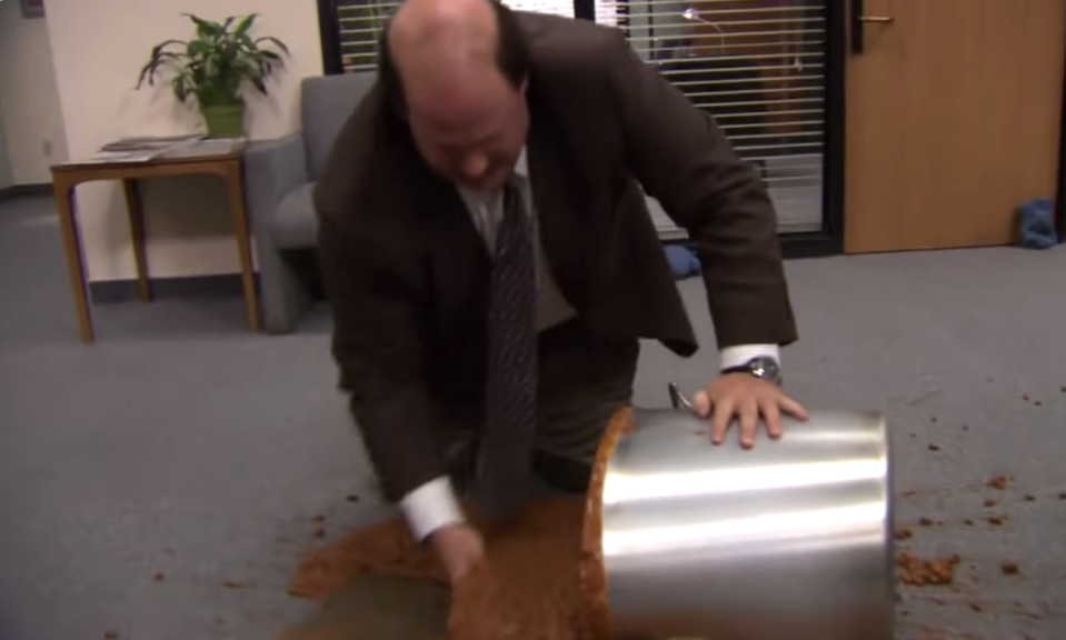 kevin from the office scooping up chili from the floor