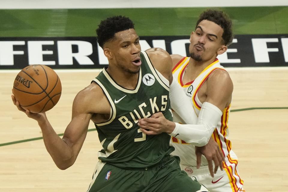 Milwaukee Bucks' Giannis Antetokounmpo tries to get past Atlanta Hawks' Trae Young during the first half of Game 1 of the NBA Eastern Conference basketball finals game Wednesday, June 23, 2021, in Milwaukee. (AP Photo/Morry Gash)