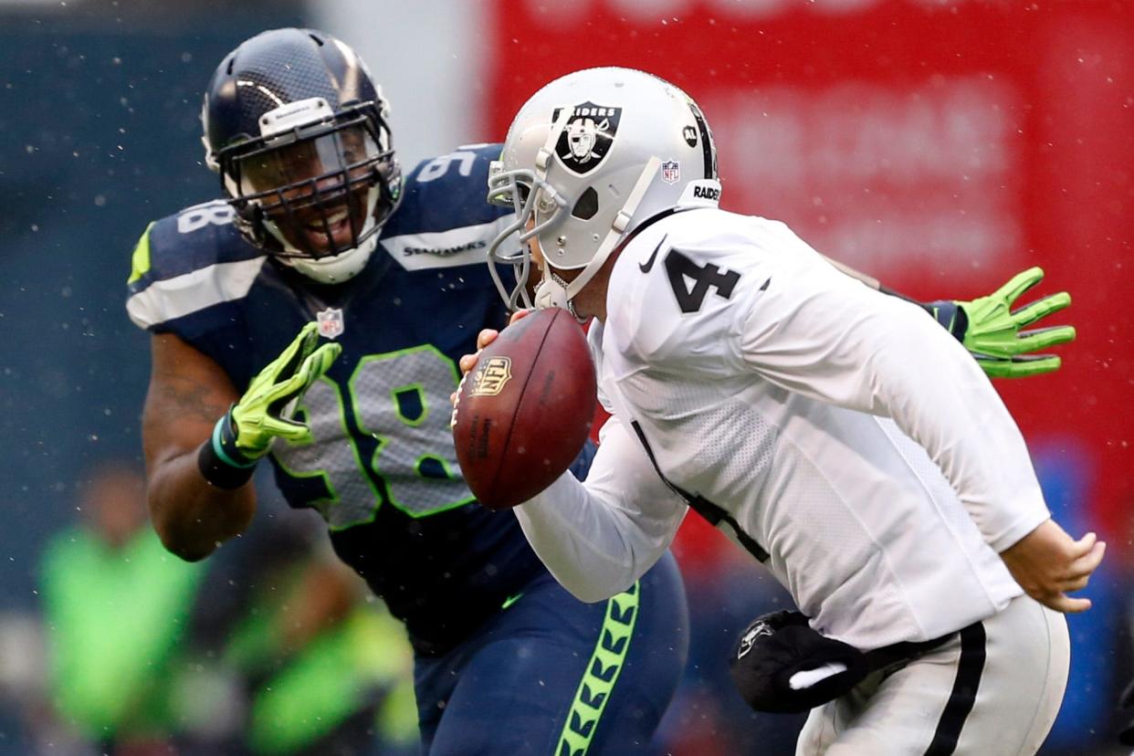 Oakland Raiders quarterback Derek Carr scrambles away from Seattle Seahawks defensive end Greg Scruggs during the second quarter at CenturyLink Field, Nov. 2, 2014 in Seattle.