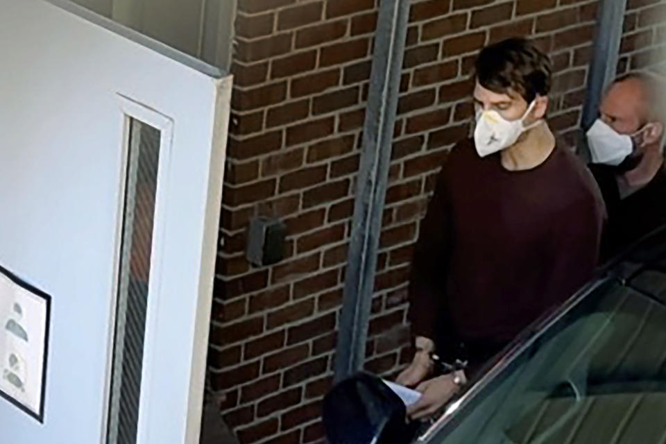 In this image taken from video provided courtesy of WCVB-TV, Nathan Carman, front, is escorted in to federal court on Wednesday, May 11, 2022, in Rutland, Vt. Carman, who was rescued from a raft off the coast of New England in 2016 after his boat sank, pleaded not guilty Wednesday to charges he killed his mother at sea to inherit the family's estate. (Sera Congi/WCVB-TV via AP)
