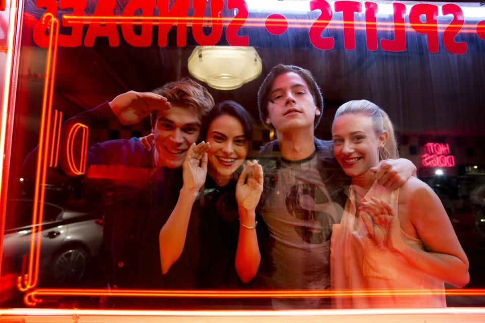 KJ Apa, Camila Mendes, Cole Sprouse, and Lili Reinhart looking through a window behind the scenes of season one of "Riverdale."
