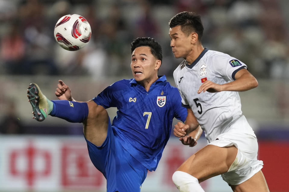 Thailand's Supachok Sarachat, left, is challenged by Kyrgyzstan's Bekzhan Sagynbaev during the Asian Cup Group F soccer match between Kyrgyzstan and Thailand at Abdullah Bin Khalifa Stadium in Doha, Qatar, Tuesday, Jan. 16, 2024. (AP Photo/Thanassis Stavrakis)