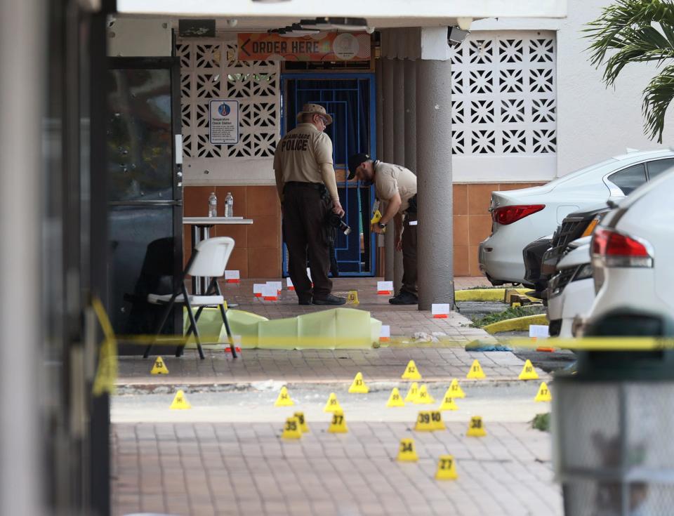 Miami-Dade police mark where shell casings fell in a mass shooting outside a banquet hall May 30 in Hialeah, Fla. Two people died, and more than 20 were injured.