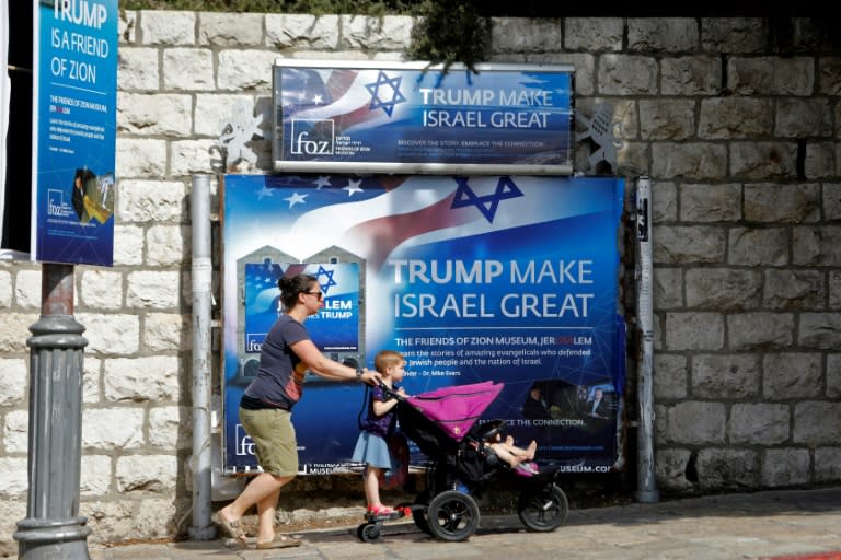 People walk past a banner in support of US President Donald Trump on the day of his visit in Jerusalem on May 22, 2017