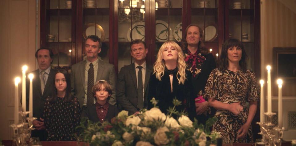 A group of guests standing in front of a dining table on season one, episode 10 of "Gossip Girl."