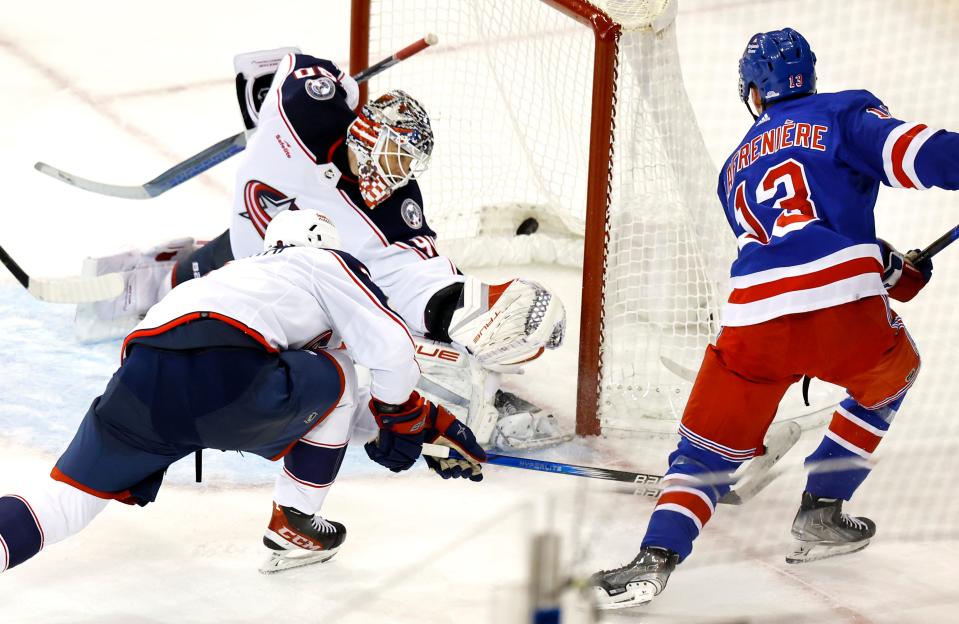 New York Rangers left wing Alexis Lafreniere (13) scores a goal against Columbus Blue Jackets goaltender Elvis Merzlikins (90) and defenseman Ivan Provorov during the third period of an NHL hockey game, Sunday, Nov. 12, 2023, in New York. (AP Photo/Noah K. Murray)