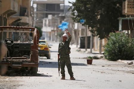 A Syria Democratic Forces (SDF) fighter gestures on a street in Manbij, in Aleppo Governorate, Syria, August 7, 2016. REUTERS/Rodi Said