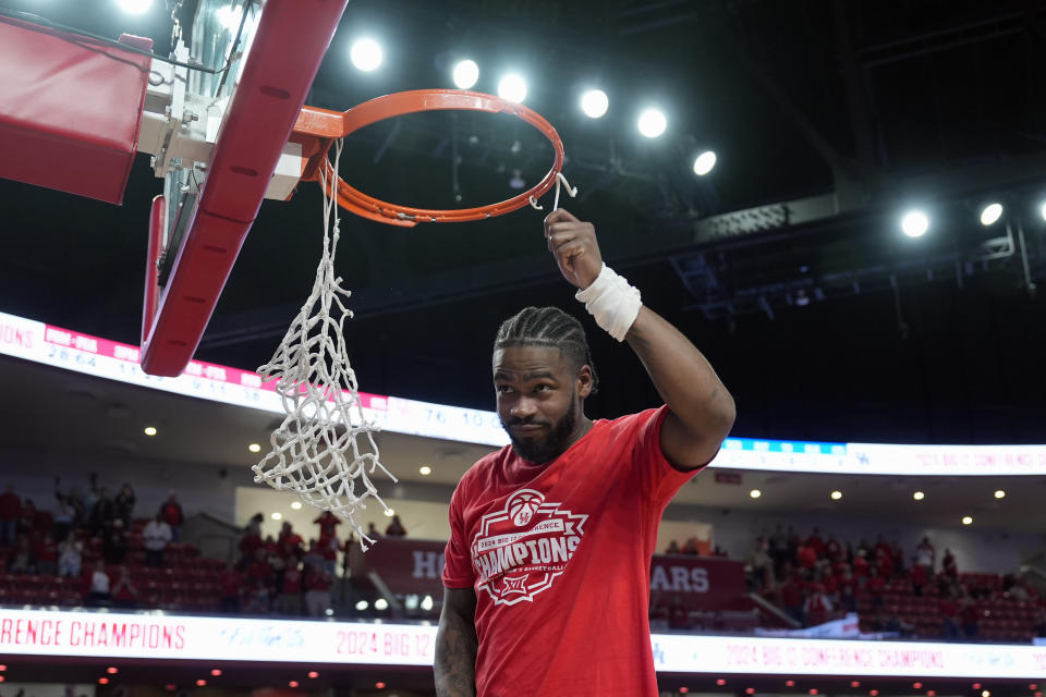 Houston's Jamal Shead cuts down a piece of the net after an NCAA college basketball game against Kansas Saturday, March 9, 2024, in Houston. Houston won 76-46 and finished the regular season as the Big 12 Conference Champions. (AP Photo/David J. Phillip)