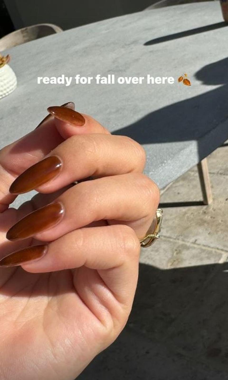 Manicura otoñal de Hailey Bieber con anillo MOM