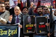 Members of the Confederation of All India Traders hold placards and shout slogans during a protest against the visit of Jeff Bezos to India, in New Delhi