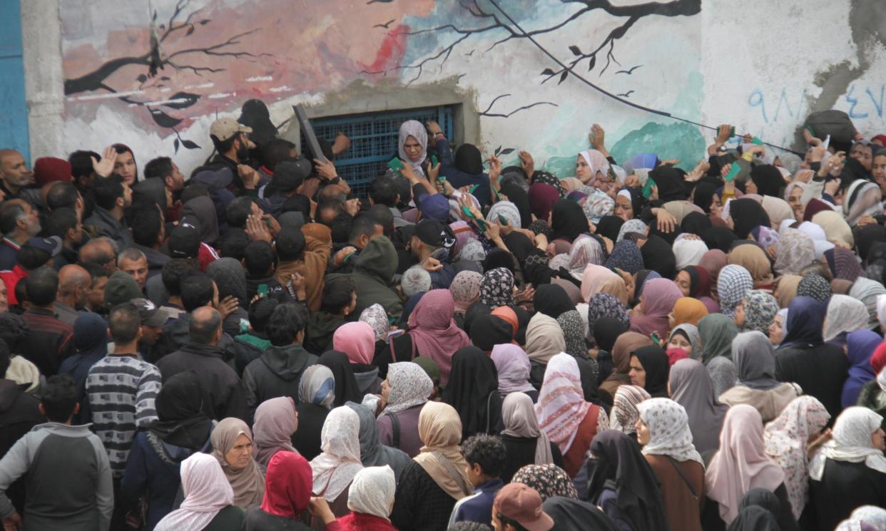 <span>People wait for flour outside the Unrwa distribution centre in Gaza City last month.</span><span>Photograph: Anadolu/Getty Images</span>