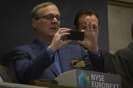 Microsoft co-founder Paul Allen takes a photo prior to ringing the opening bell at the New York Stock Exchange January 30, 2014. REUTERS/Brendan McDermid