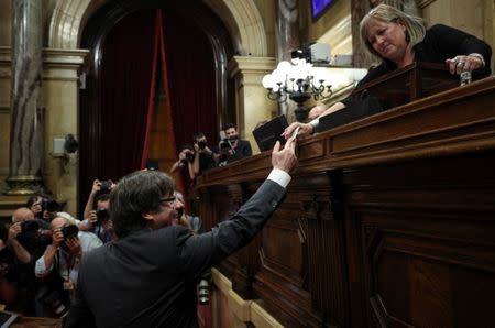 Catalan President Puigdemont hands in his ballot during a vote on independence from Spain at the Catalan regional Parliament in Barcelona, Spain, October 27, 2017. REUTERS/Albert Gea