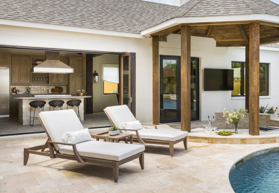 <p>"We designed this outdoor kitchen and bar for a family of five who loves spending their time poolside," says Houston-based designer <a href="https://marieflanigan.com/" rel="nofollow noopener" target="_blank" data-ylk="slk:Marie Flanigan;elm:context_link;itc:0;sec:content-canvas" class="link ">Marie Flanigan</a>. "With a sunken bar, full kitchen, hibachi grill, and crawfish station, it’s truly an outdoor entertainer's dream! Natural wood cabinetry and hand-painted tiles feel casual and welcoming, and the concrete counters are practically indestructible."</p>