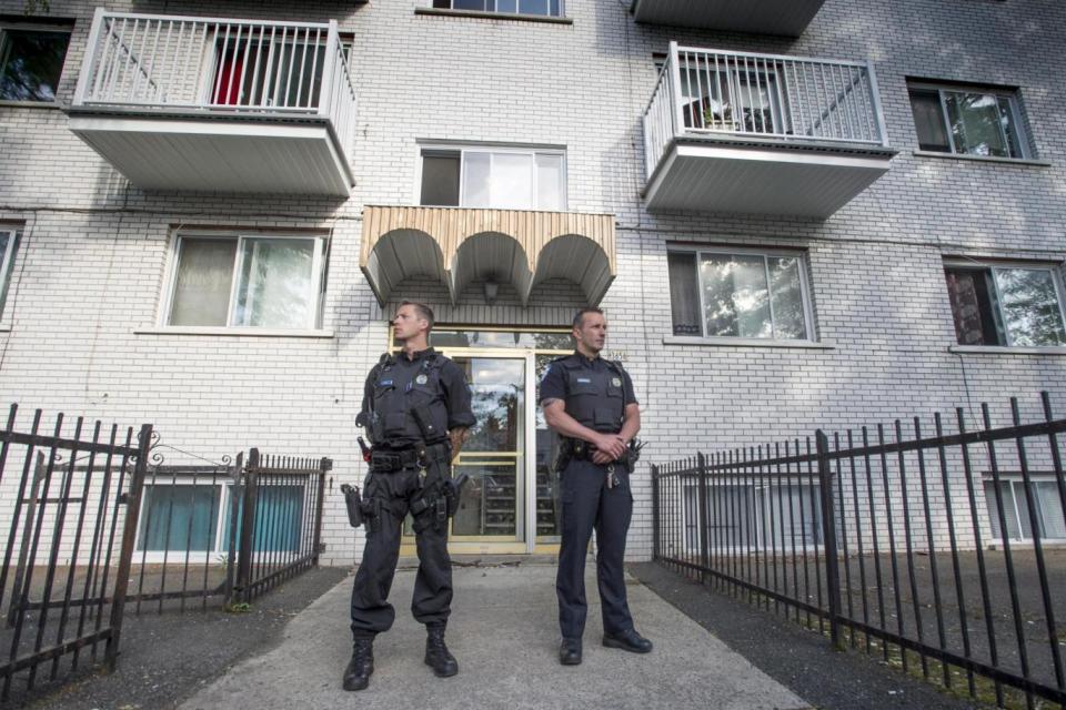 Police stand guard in front of an apartment building in Montreal (AP)