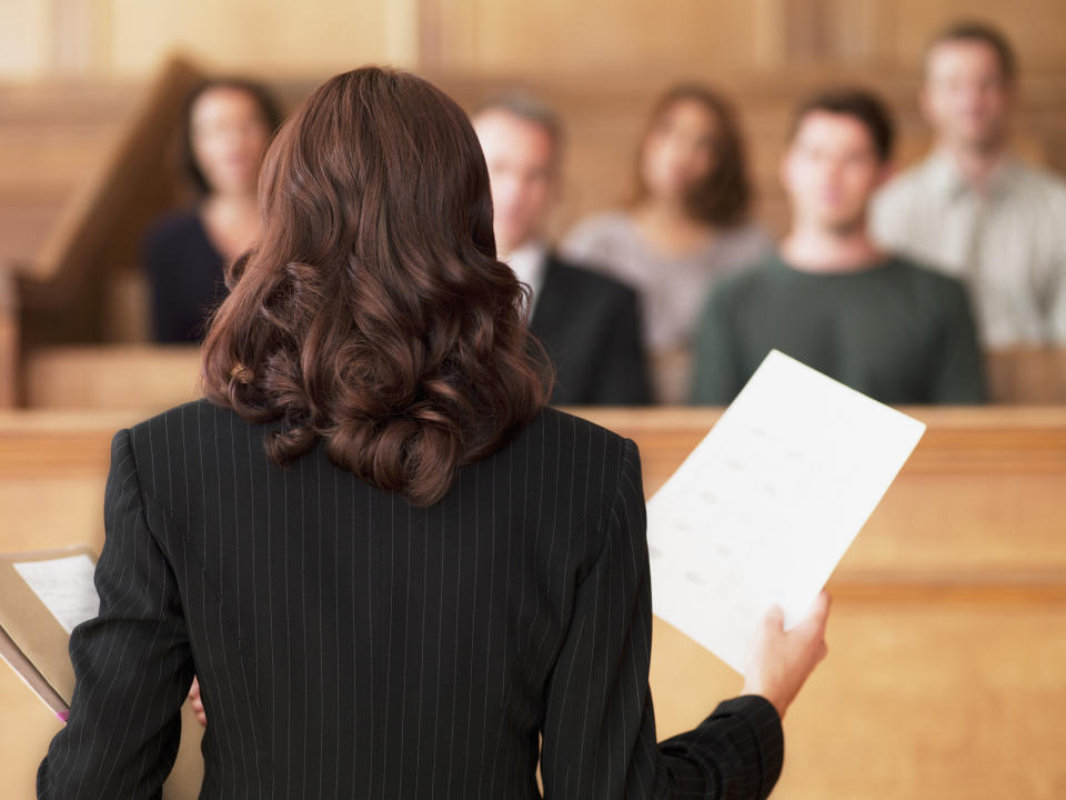 the back of a lawyer as she addresses the jury