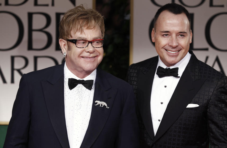 FILE - Elton John, left, and David Furnish arrive at the 69th Annual Golden Globe Awards Sunday, Jan. 15, 2012, in Los Angeles. A new exhibition of photographs owned by Elton John opens this week at London’s Victoria and Albert Museum. It includes more than 300 pieces by 140 photographers selected from the vast collection of John and his husband David Furnish. (AP Photo/Matt Sayles, File)