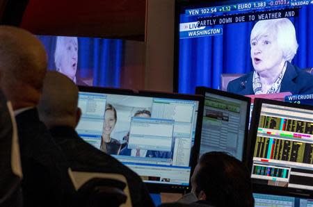 A screen displays a news conference by Federal Reserve Chair Janet Yellen as traders work on the floor of the New York Stock Exchange March 19, 2014. REUTERS/Brendan McDermid