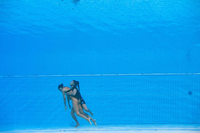 TOPSHOT - USA's coach Andrea Fuentes (R) recovers USA's Anita Alvarez (L), from the bottom of the pool during an incident in the women's solo free artistic swimming finals, during the Budapest 2022 World Aquatics Championships at the Alfred Hajos Swimming Complex in Budapest on June 22, 2022. (Photo by Oli SCARFF / AFP) (Photo by OLI SCARFF/AFP via Getty Images)