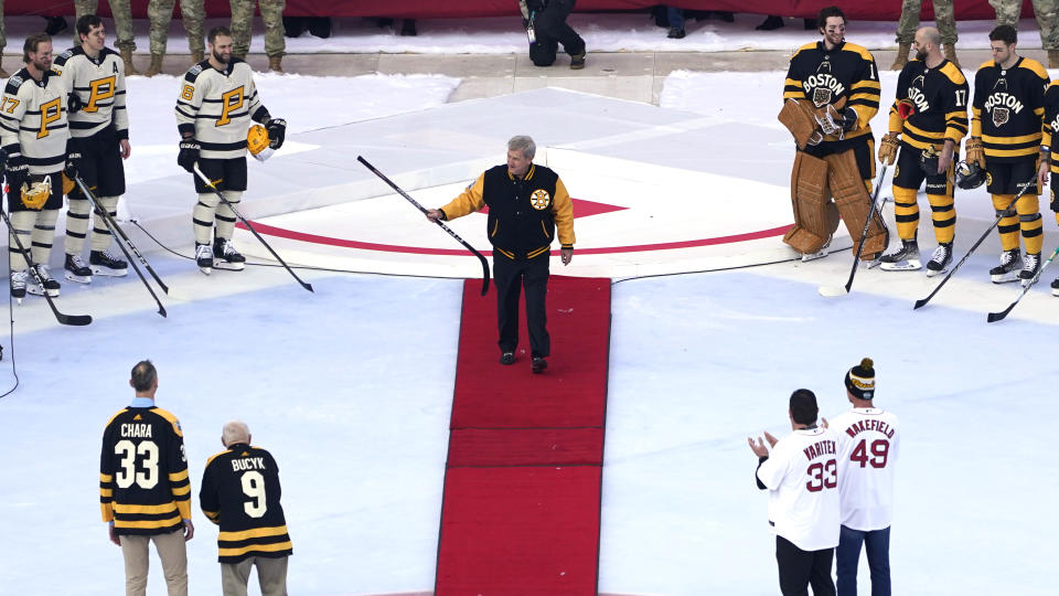 Hall of Fame hockey legend Bobby Orr raises his stick while introduced prior to the NHL Winter Classic hockey game between the Pittsburgh Penguins and Boston Bruins at Fenway Park, Monday, Jan. 2, 2023, in Boston. (AP Photo/Charles Krupa)