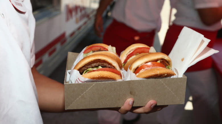 Employee holding In-N-Out burgers