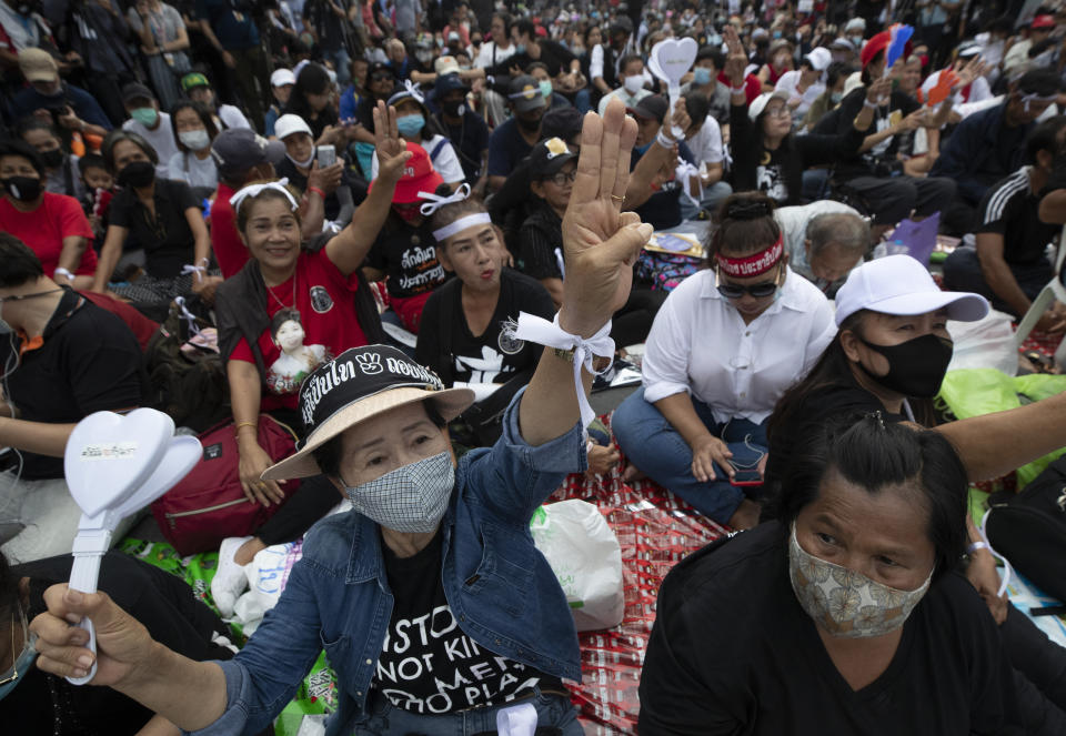 Pro-democracy demonstrators raise a three-finger salute, a symbol of resistance, during a protest outside the Parliament in Bangkok, Thailand, Thursday, Sept. 24, 2020. Lawmakers in Thailand are expected to vote Thursday on six proposed amendments to the constitution, as protesters supporting pro-democratic charter reforms gathered outside the parliament building. (AP Photo/Sakchai Lalit)