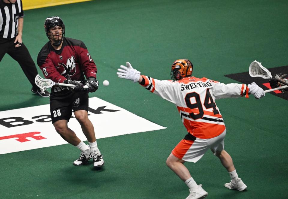 Zed Williams of the Colorado Mammoth, left, shoots past Buffalo Bandit Bryce Sweeting during Game 2 of the National Lacrosse League Finals in May 2023.