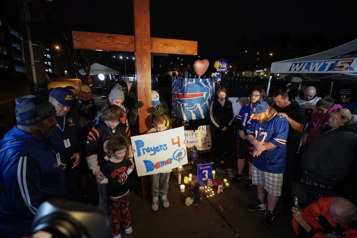 People pray during a prayer vigil for Buffalo Bills’ Damar Hamlin outside of University of Cincinnati Medical Center, Tuesday, Jan. 3, 2023, in Cincinnati. (AP Photo/Darron Cummings, File)