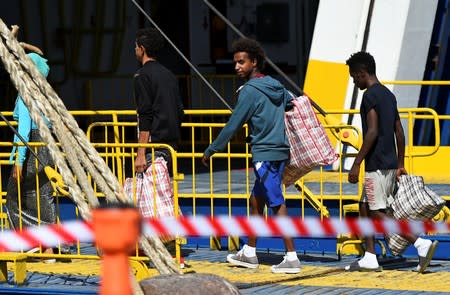 Migrants embark a ferry to the mainland, in Lampedusa