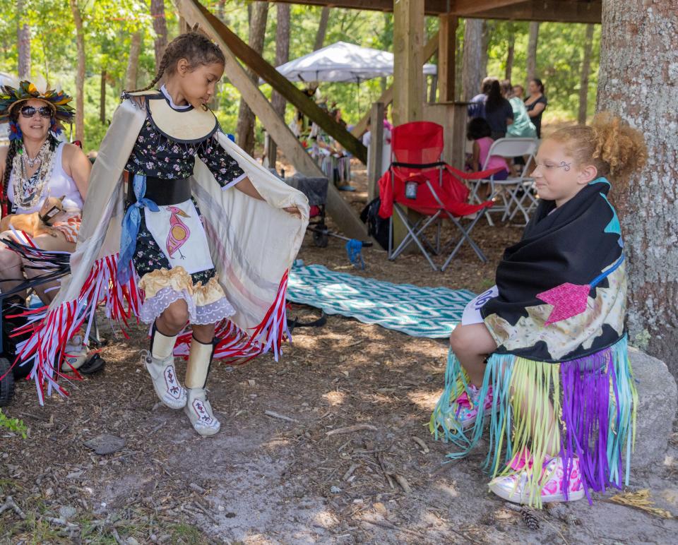 Akinnah Gonzalez, 6, watch Nailani LuzCaban Gomes, 9, practice dancing before the opening ceremony starts at the Wampanoag Powwow Grounds in Mashpee on Friday. 
Sophie Proe/Cape Cod Times