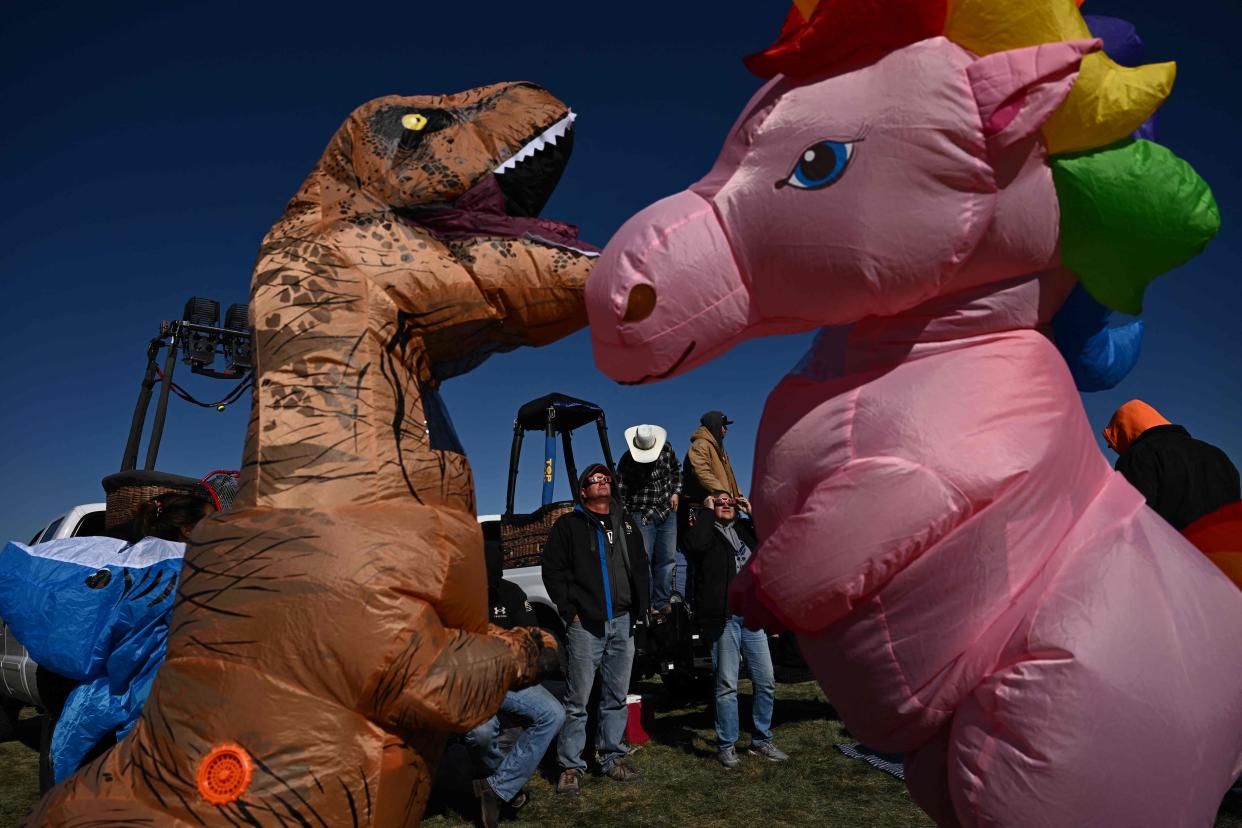 People dress in costumes as others watch the annular solar eclipse at the 51st Albuquerque International Balloon Fiesta in Albuquerque, New Mexico, on October 14, 2023.