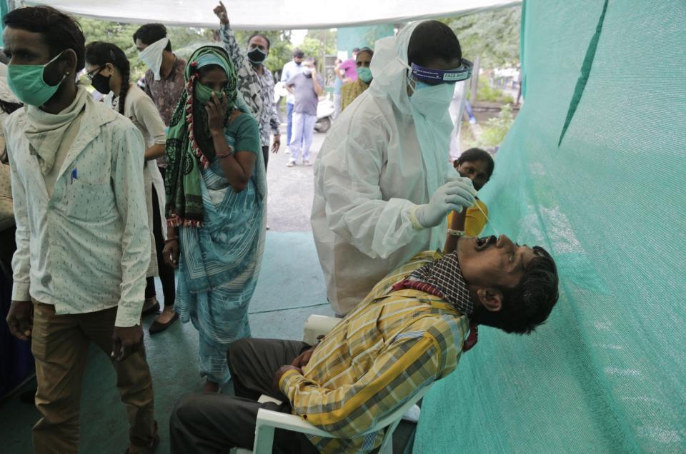 A health worker takes a nasal swab sample to test for COVID-19 in Ahmedabad, India.