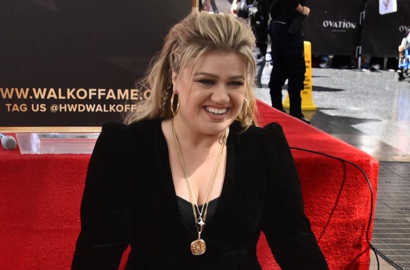 Kelly Clarkson kneels next to her star during an unveiling ceremony honoring her with the 2,733rd star on the Hollywood Walk of Fame in Los Angeles in 2022. File Photo by Jim Ruymen/UPI