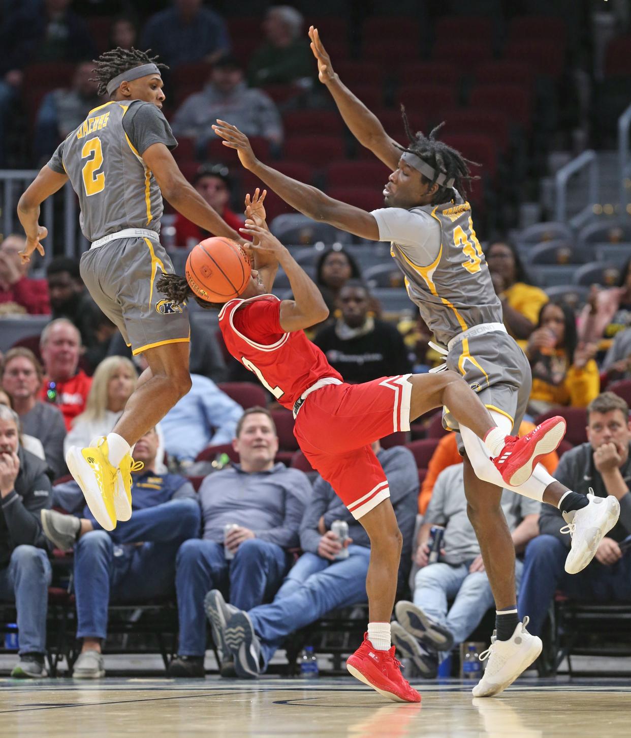 Miami's Mekhi Lairy is stuffed by Kent State's Malique Jacobs (left) and Akeeem Odusipe in Thursday's Mid-American Conference quarterfinal game on in Cleveland, Ohio, at Rocket Mortgage FieldHouse.