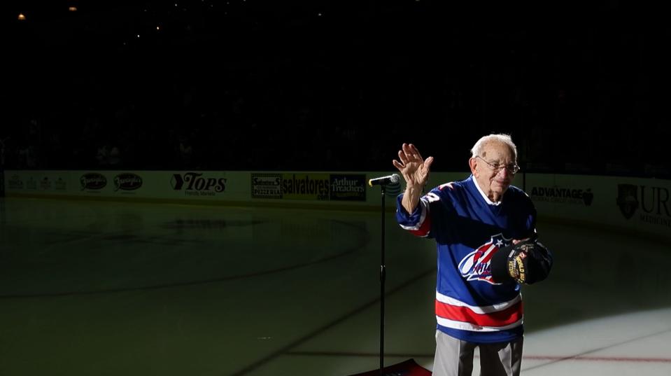 93-year-old "Harmonica Pete" DuPre waves to the crowd after performing the national anthem on the harmonica.