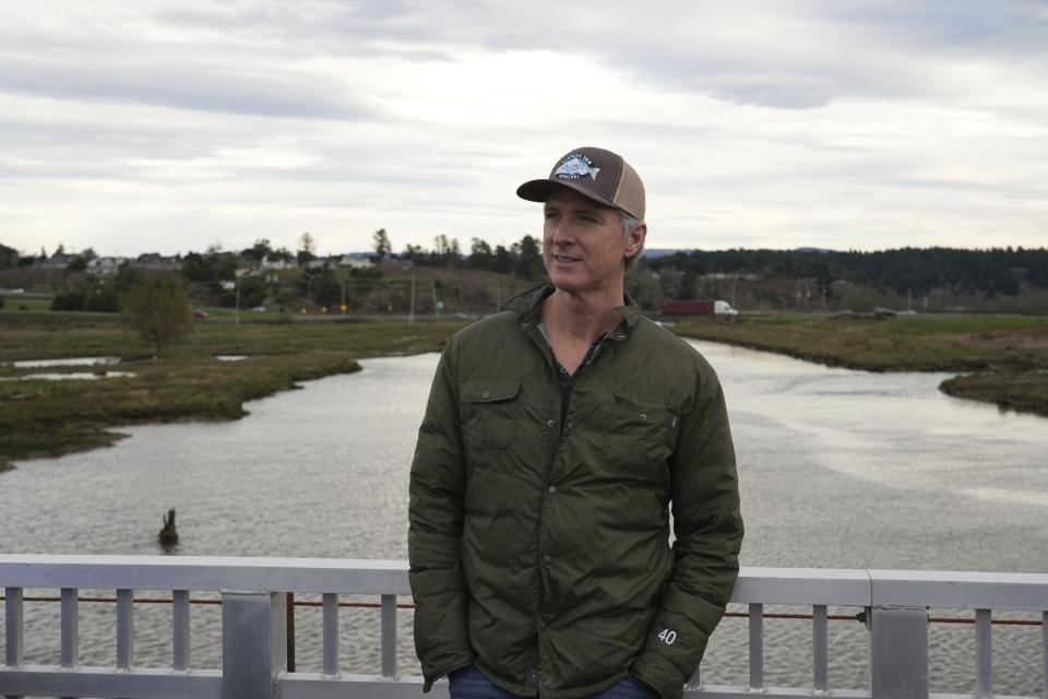 California Gov. Gavin Newsom stands on a bridge overlooking the Elk River where he was touring a salmon restoration project int in Eureka, Calif., Monday, Jan. 29, 2024. (AP Photo/Terry Chea)