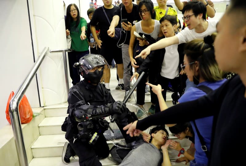 Riot police officer detains a protester at a shopping mall in Tai Po in Hong Kong