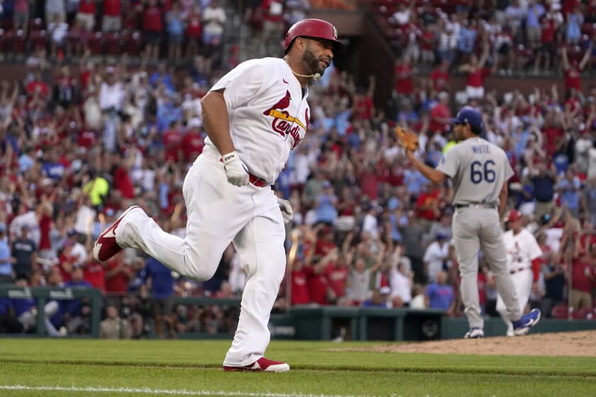 St. Louis Cardinals' Albert Pujols, left rounds the bases after hitting a solo home run off Los Angeles Dodgers starting pitcher Mitch White (66) during the second inning of a baseball game Tuesday, July 12, 2022, in St. Louis. (AP Photo/Jeff Roberson)
