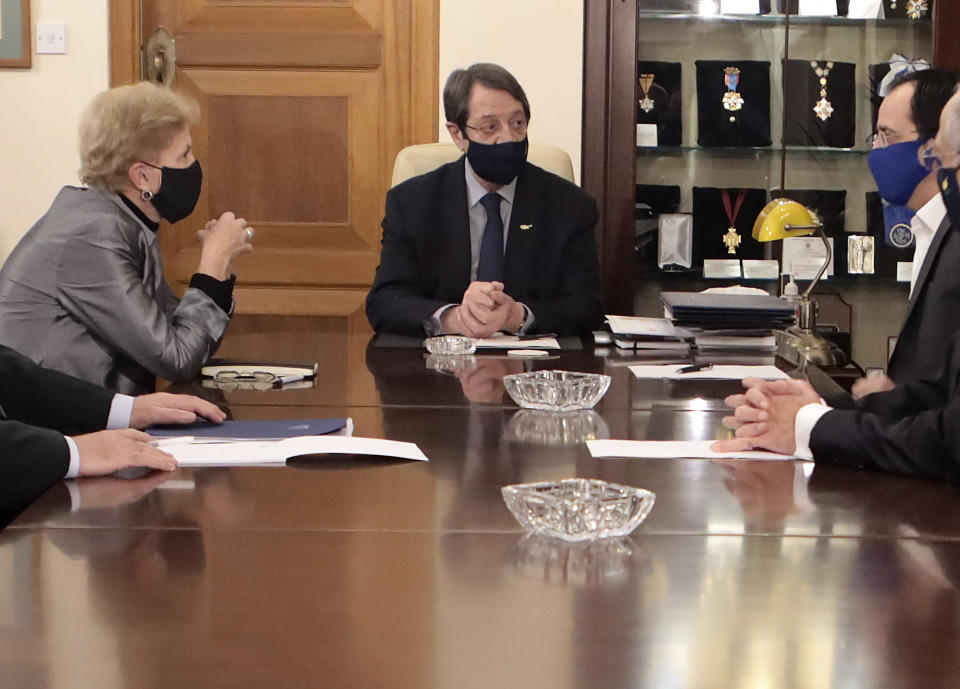 In this photo released from Cyprus' Press and Informations Office, Cyprus President Nicos Anastasiades, center, United Nations Secretary General advisor Jane Holl Lute, left, and Cyprus' foreign minister Nicos Christodoulides, right, talk during their meeting at the presidential palace in divided capital Nicosia, Cyprus, on Tuesday, Dec. 1, 2020. Lute is meeting both leaders separately in order to prepare the ground for reunification talks. (Stavros Ioannides, Cyprus' Press and Informations Office via AP)