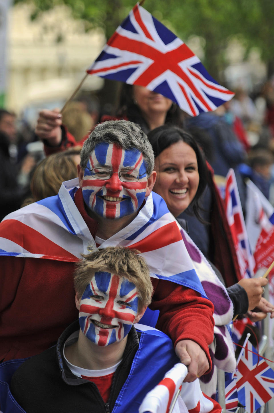 Spectators wait for Britain's Queen Elizabeth II and the royal family to pass along The Mall for a service of thanksgiving at St Paul's Cathedral as part of the Diamond Jubilee celebrations Tuesday June 5, 2012. Queen Elizabeth II will make a rare address to the nation at the conclusion of festivities marking her 60 years on the throne. (AP Photo/Tom Hevezi)