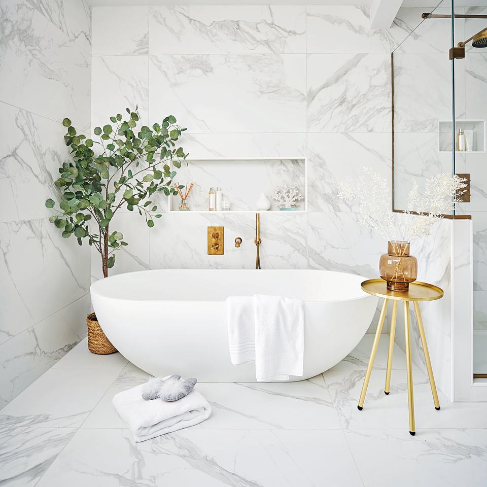 White bathroom with freestanding bath and plant