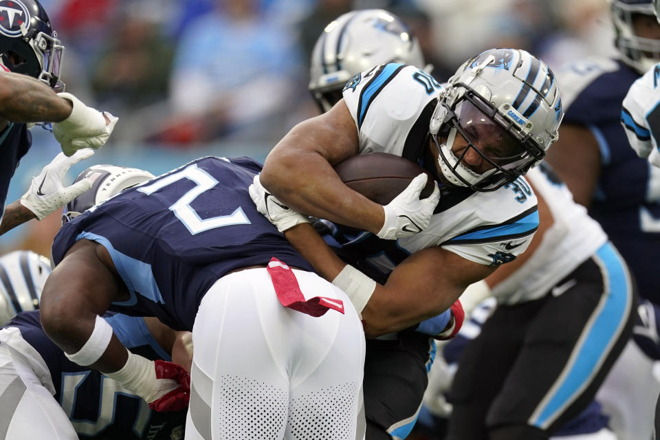 Carolina Panthers running back Chuba Hubbard (30) is stopped by Tennessee Titans linebacker Azeez Al-Shaair (2) during the first half of an NFL football game Sunday, Nov. 26, 2023, in Nashville, Tenn. (AP Photo/George Walker IV)